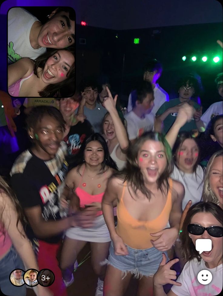 a group of people standing around each other at a party with their arms in the air