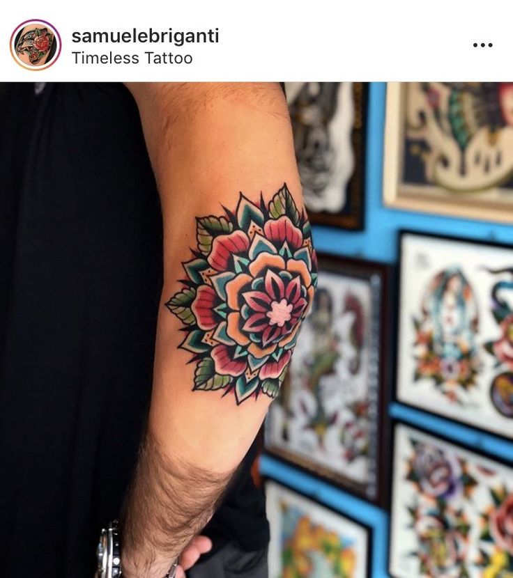 a man's arm with a flower tattoo on the left side of his arm