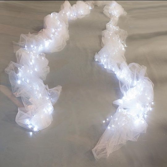 there is a white string of lights in the shape of a wreath on top of a bed