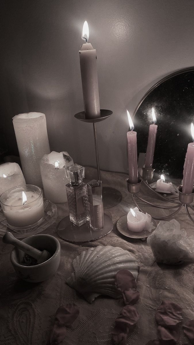 a table topped with lots of candles and seashells