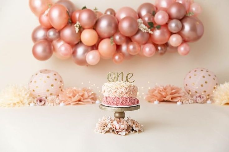 a cake sitting on top of a table next to balloons