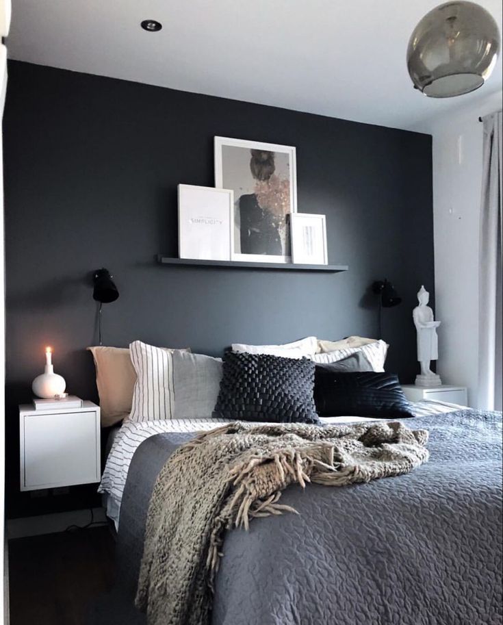 a bedroom with black walls and white bedding