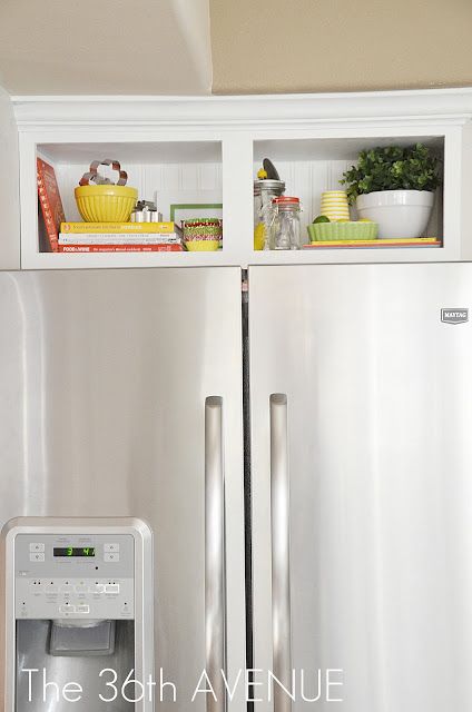 a stainless steel refrigerator and freezer combo in a kitchen with open shelves above it