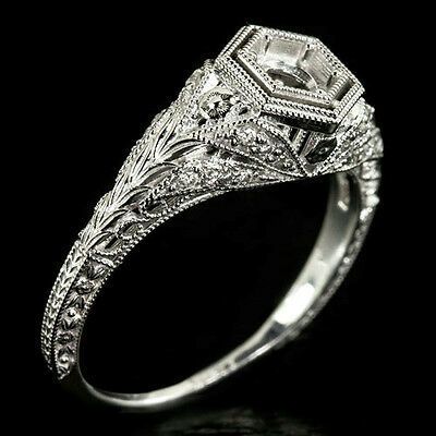 an antique style diamond engagement ring on a black background