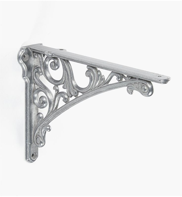 an ornate metal shelf bracket on a white wall