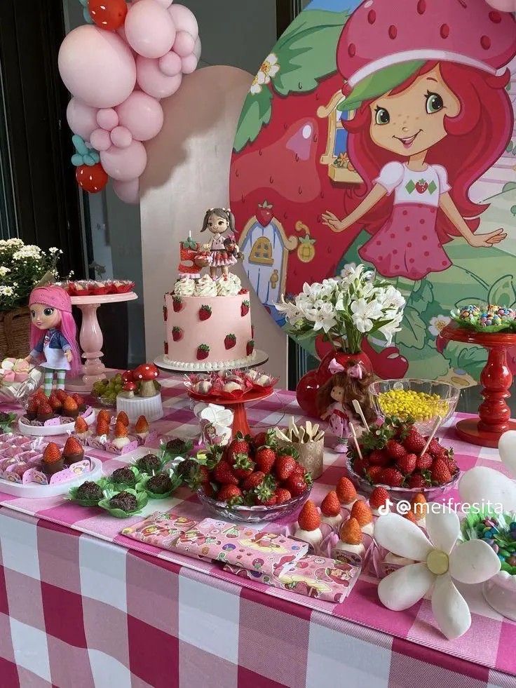 a table topped with lots of cake and desserts next to a giant pink balloon