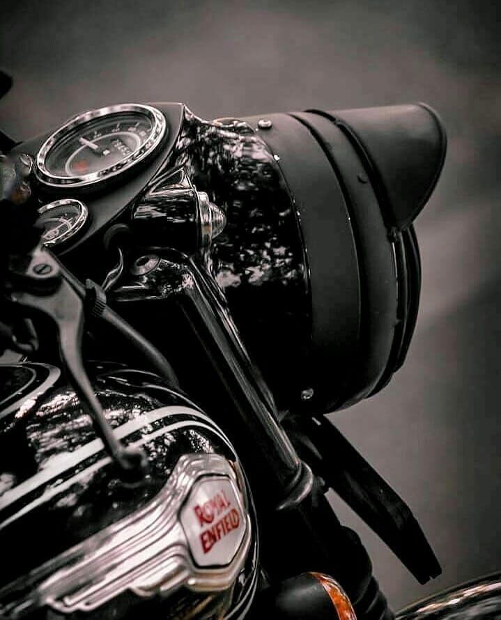 the front end of a black motorcycle with a clock on it's handlebars