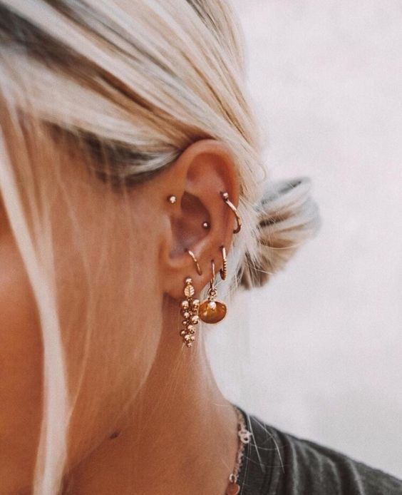 a woman with blonde hair wearing gold earrings