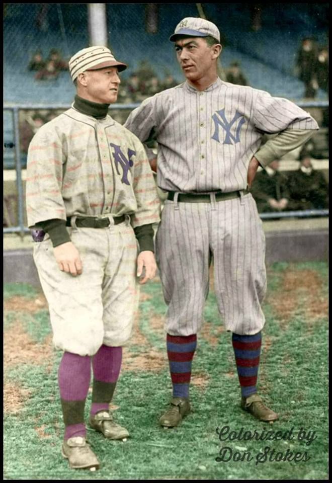 two baseball players standing next to each other on a field