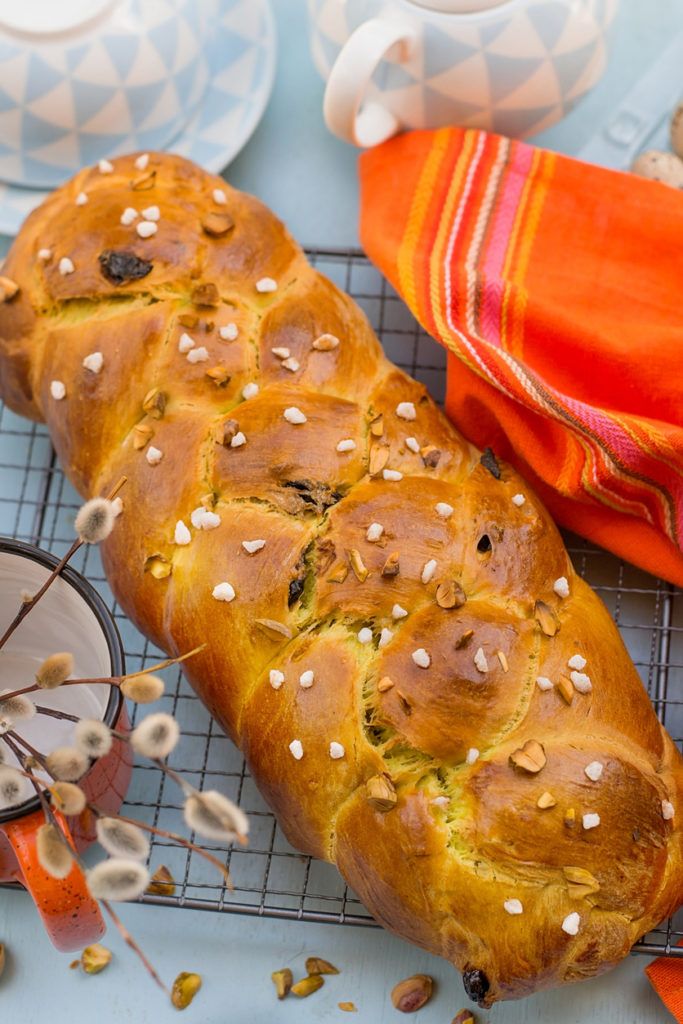 a loaf of bread sitting on top of a cooling rack next to cups and saucers