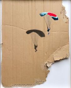 a cardboard box with a kite flying in the sky on it's bottom half