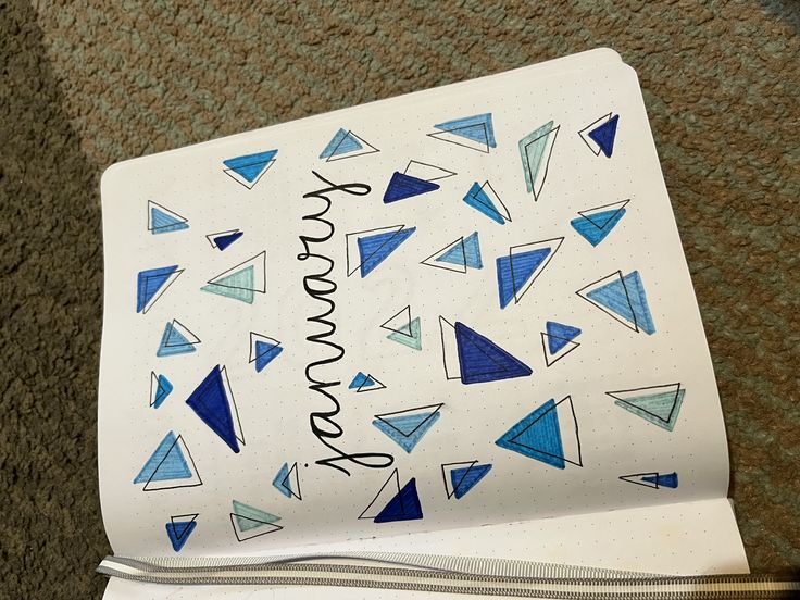 an open notebook with blue triangles and the words somewhere written in cursive writing