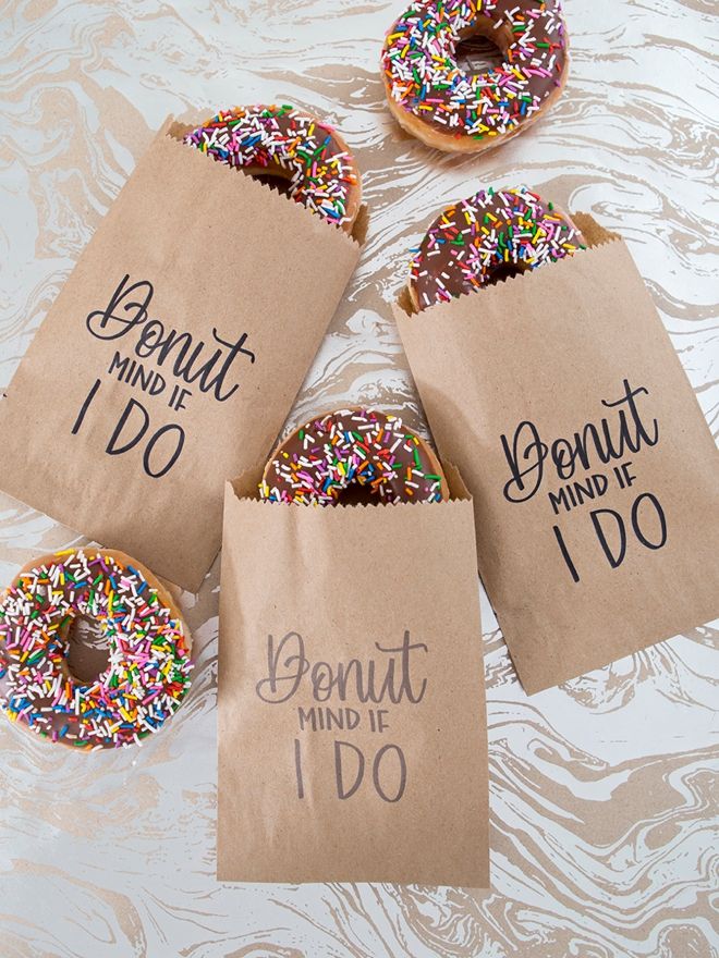 four donuts with sprinkles in brown paper bags that say, donut mind do