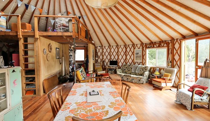 the interior of a yurt with wood floors and walls, including a dining table