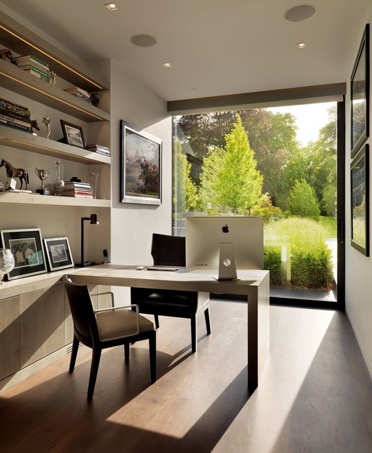 a home office with large windows and wooden flooring