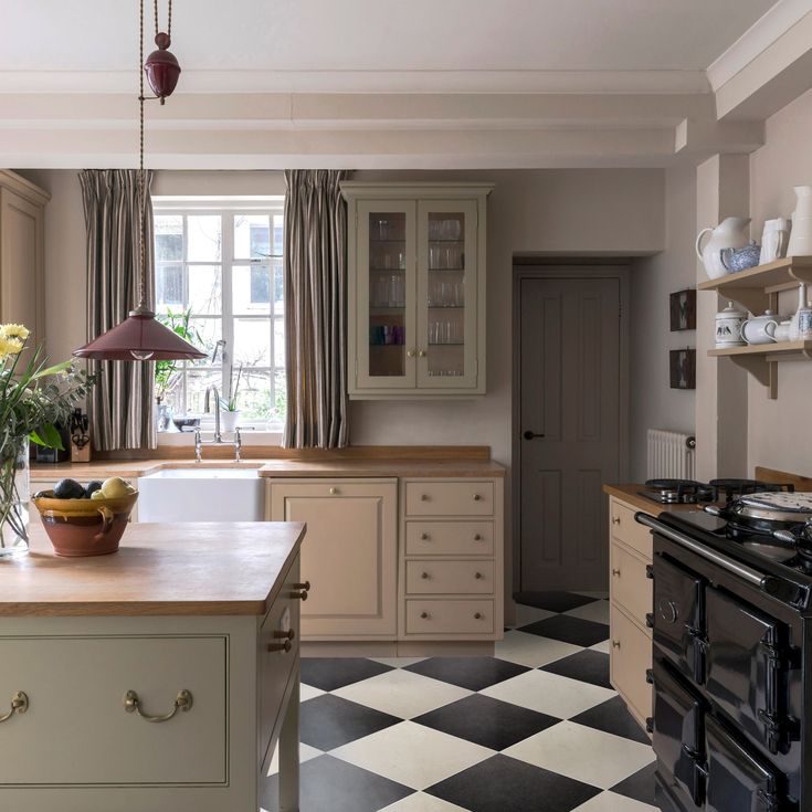 a kitchen with checkered flooring and an island in front of the stove top