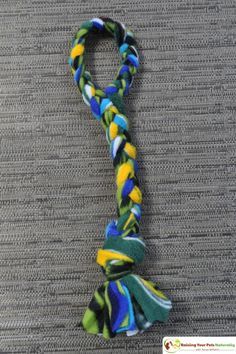 a multicolored tie that is sitting on the floor next to a gray carpet