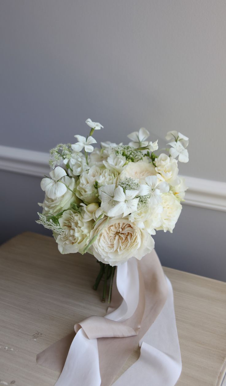 a bouquet of white flowers sitting on top of a table