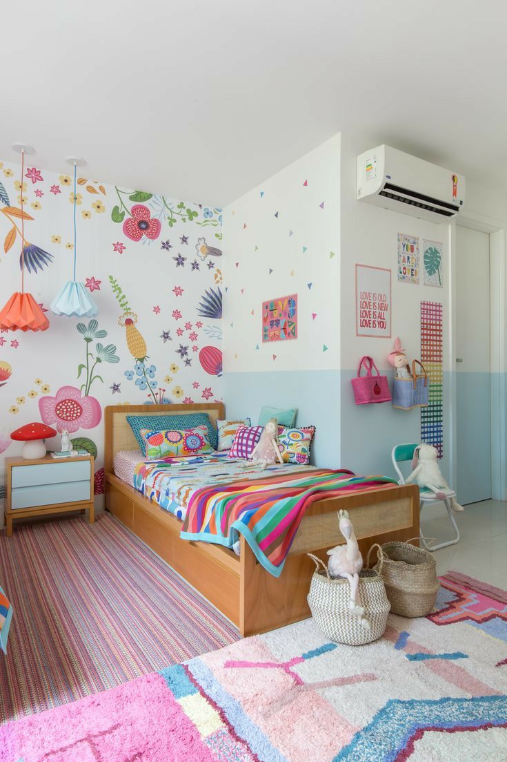 a child's bedroom decorated with colorful wallpaper and rugs on the floor