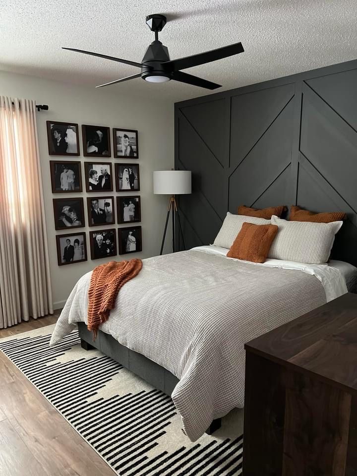 a bedroom with gray walls and pictures on the wall