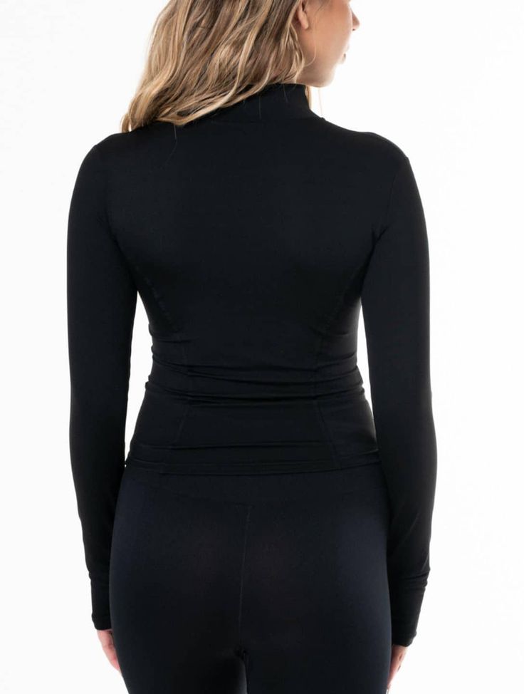 a woman in black top and leggings with her back turned to the camera