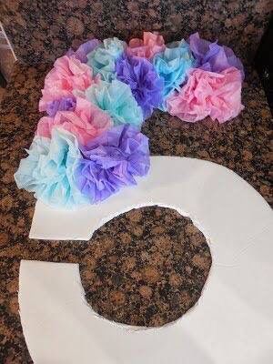 tissue paper flowers are placed on top of the letter g, which is made out of toilet paper