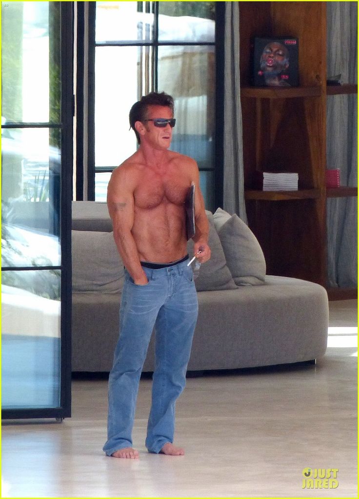 a shirtless man is standing in the living room