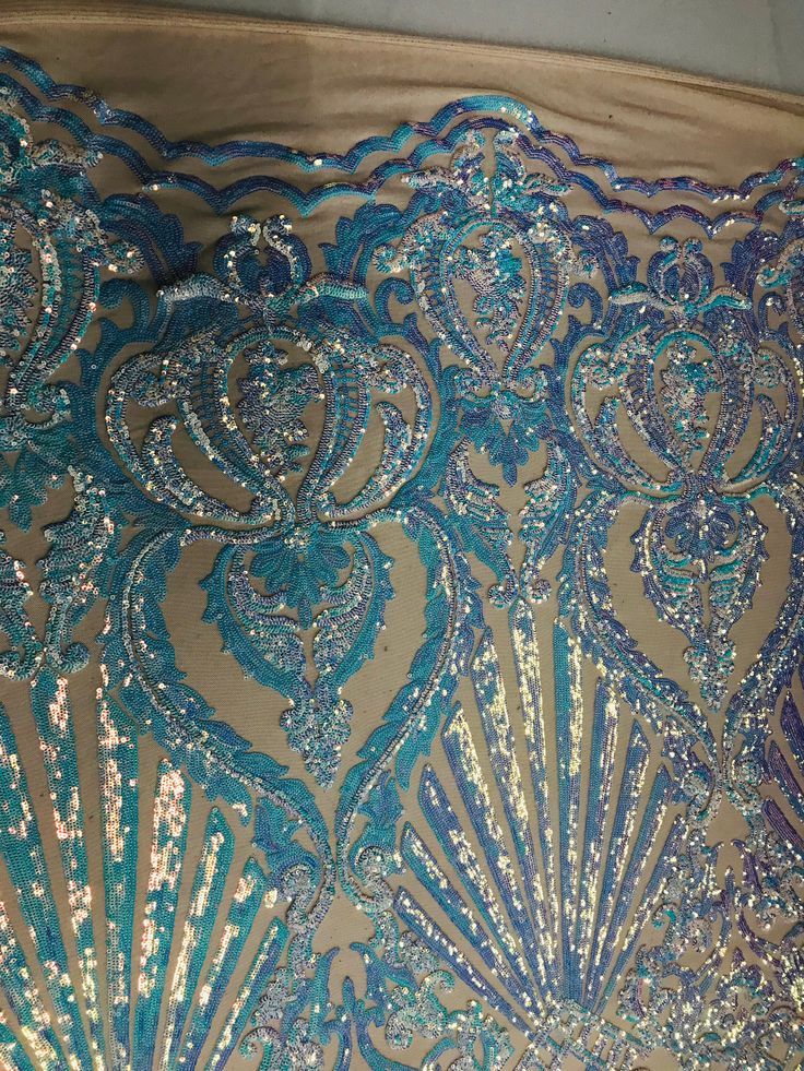 an intricately designed blue and gold cloth with sequins on the edges is shown