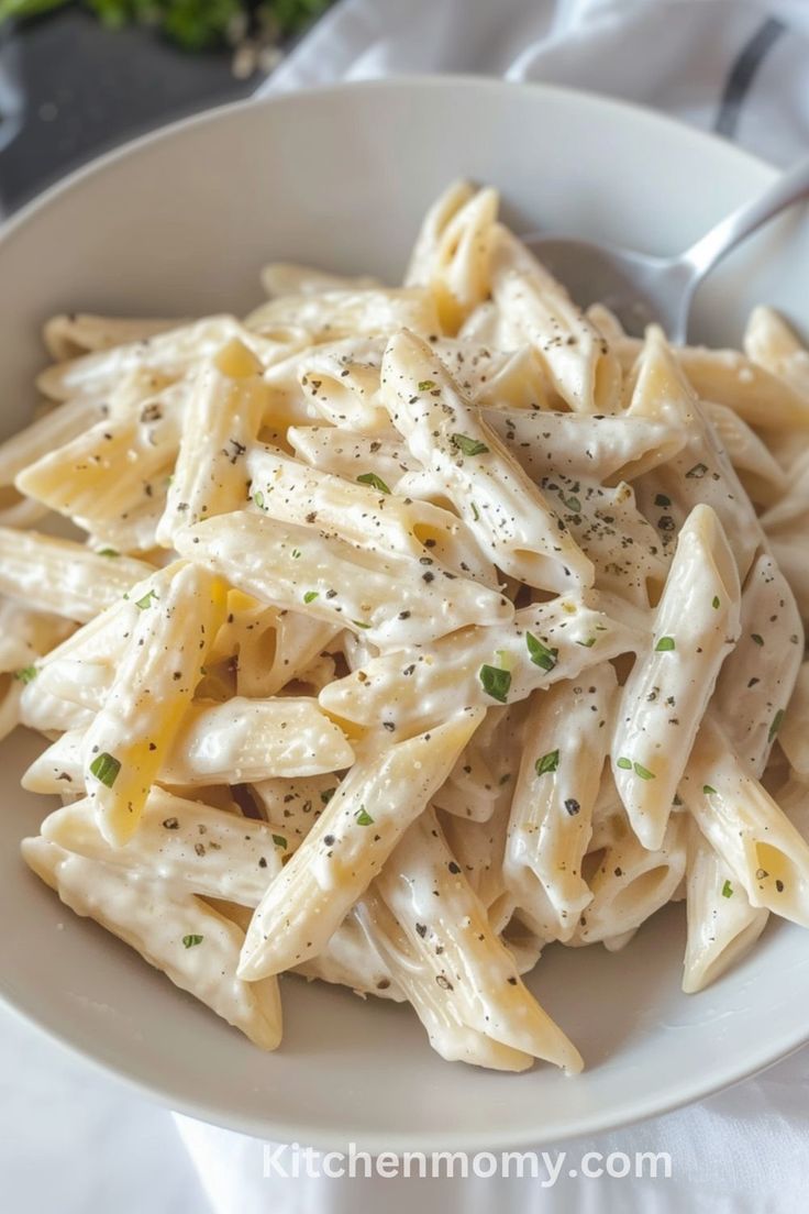 a white bowl filled with pasta and sauce