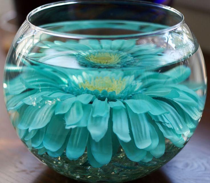 a glass vase filled with blue flowers on top of a table