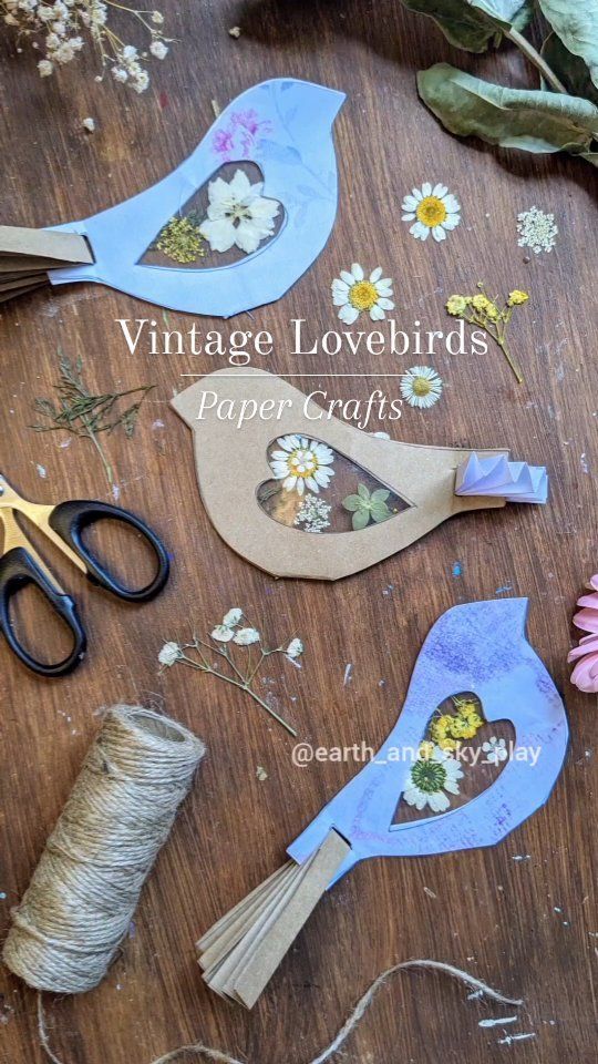 paper flowers and scissors are sitting on a wooden table with twine spools