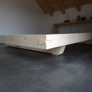 a wooden bench sitting on top of a cement floor