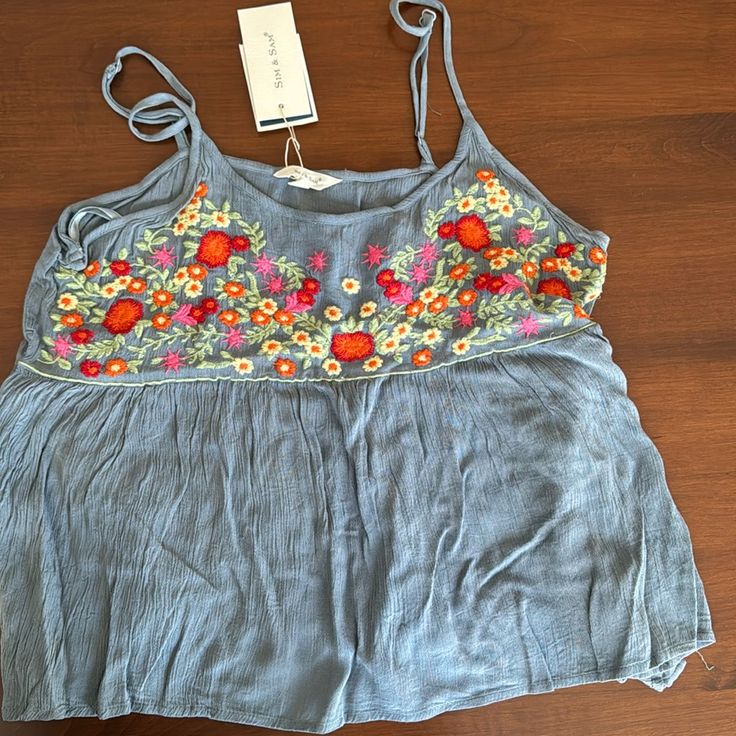 Embroidered Chest Adjustable Straps Flowy Crop Tank Summer Floral Embroidery Tops For Day Out, Summer Floral Embroidered Tops For Day Out, Light Blue Embroidered Tops For Spring, Blue Casual Top With Floral Embroidery, Casual Blue Top With Floral Embroidery, Blue Embroidered Spring Tops, Spring Embroidered Blue Tops, Blue Embroidered Tops For Spring, Blue Floral Embroidery Top For Vacation