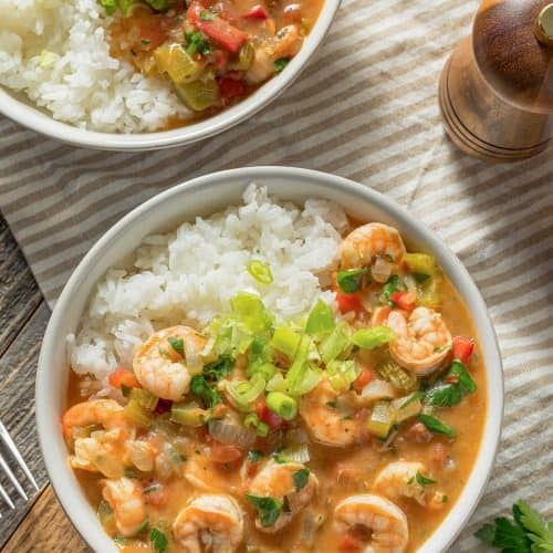 two bowls filled with shrimp and rice on top of a table