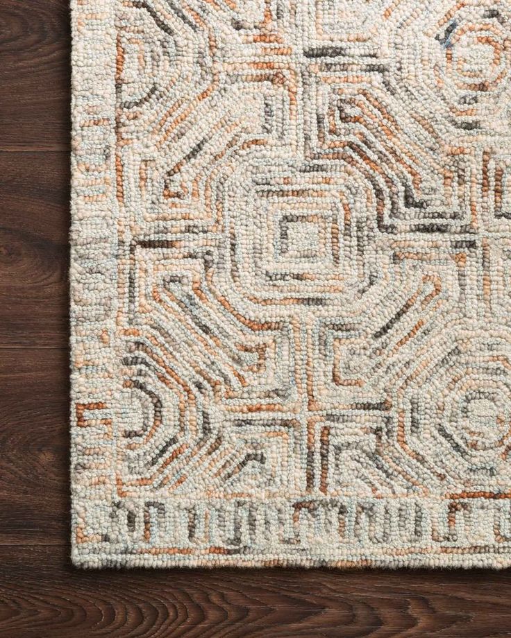 an orange and white rug on top of a wooden floor