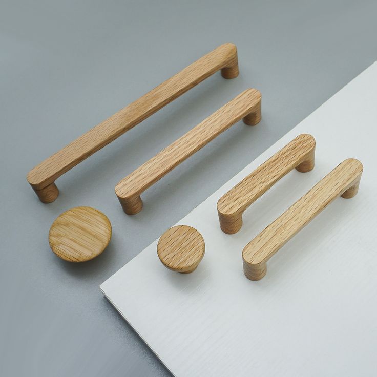 wooden handles, knobs and plates on a white board with grey surface behind them