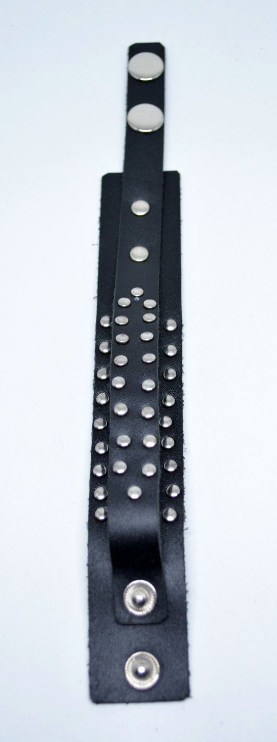 Genuine mens black leather studded bracelet with adjustable snap closure at the end. High quality handmade item, suitable for a modern urban look. Fits both men and women. Fit wrists from: 17 cm (6.69") 19 cm (7.48") to 22 cm (8.66") Width is about 3 cm (1.18") Black Edgy Wristband With Studs, Black Punk Bracelets With Studs, Punk Black Bracelets With Studs, Trendy Black Bracelets With Rivets, Black Trendy Bracelets With Studs, Trendy Black Bracelets With Studs, Black Leather Bracelet With Rivets For Concerts, Black Festival Bracelets With Spikes, Black Spiked Bracelets For Festival