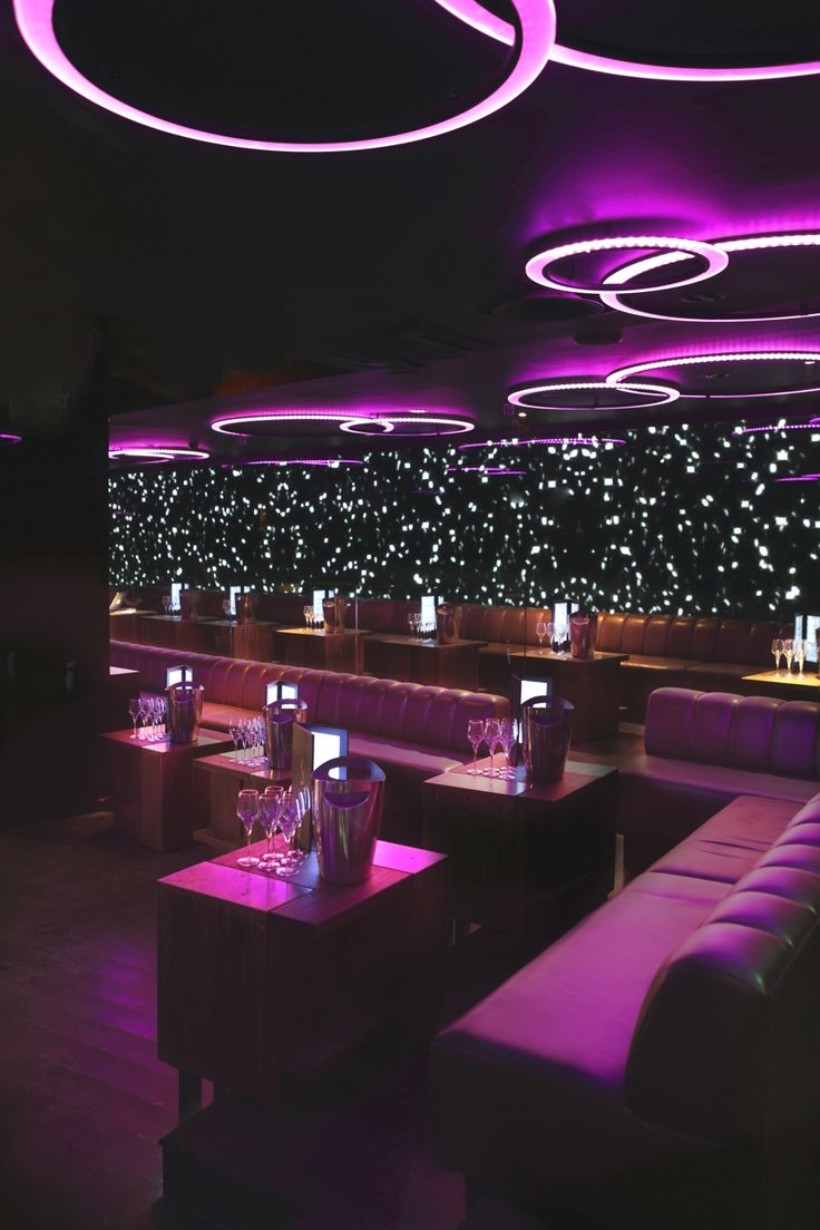 the interior of a restaurant with purple lighting