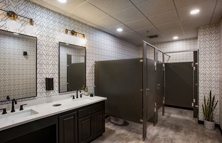 a bathroom with two sinks, mirrors and a walk - in shower next to each other