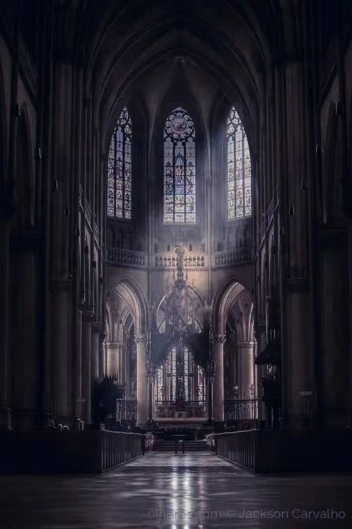 an empty cathedral with stained glass windows and pews on the floor in front of it