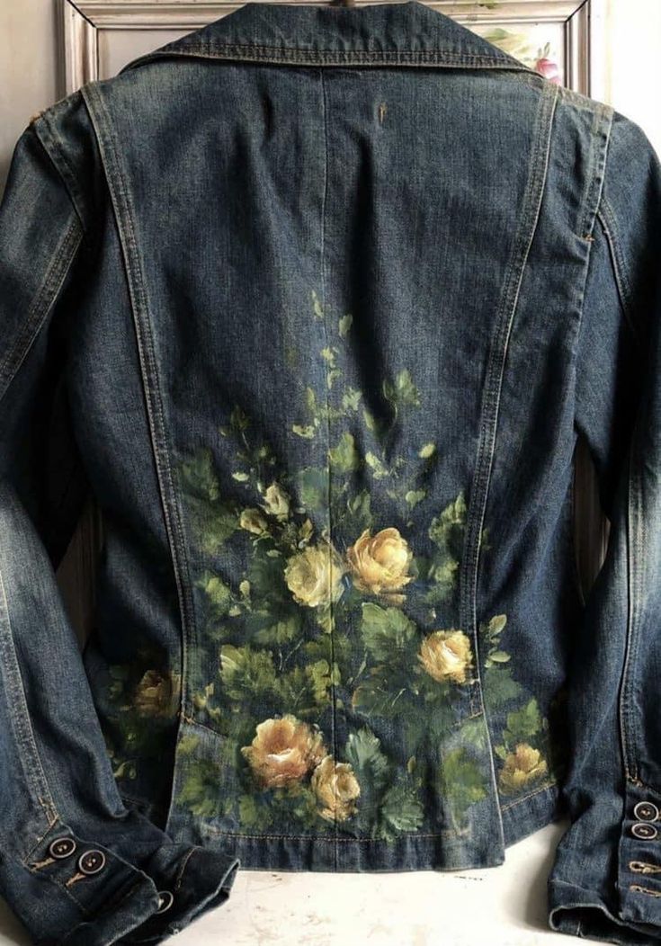 the back of a jean jacket with roses painted on it