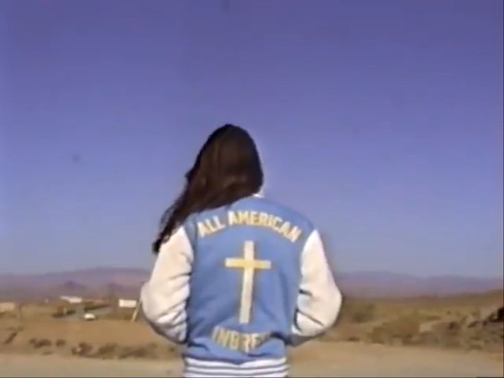 the back of a person wearing a blue and white jacket with a cross on it