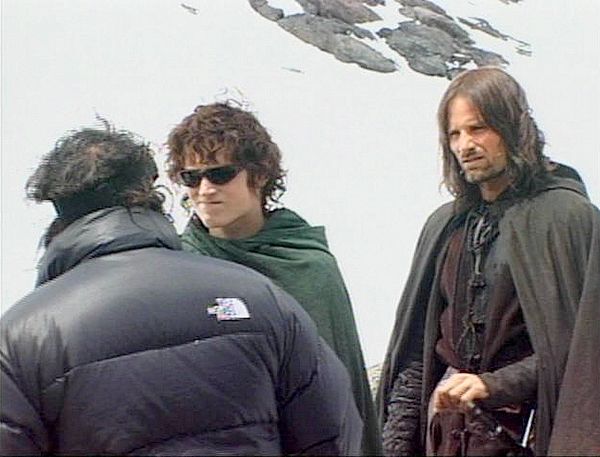 three men standing next to each other in front of a mountain