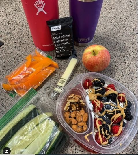 an assortment of fruits, nuts and other food items on a counter top next to cups