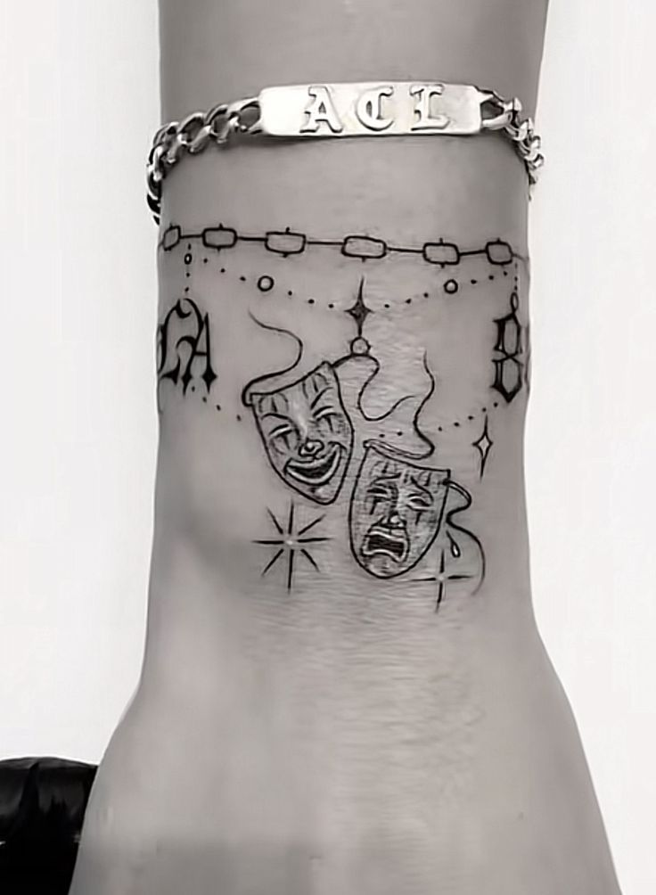 a woman's foot with a tattoo on the ankle that has two pieces of jewelry attached to it