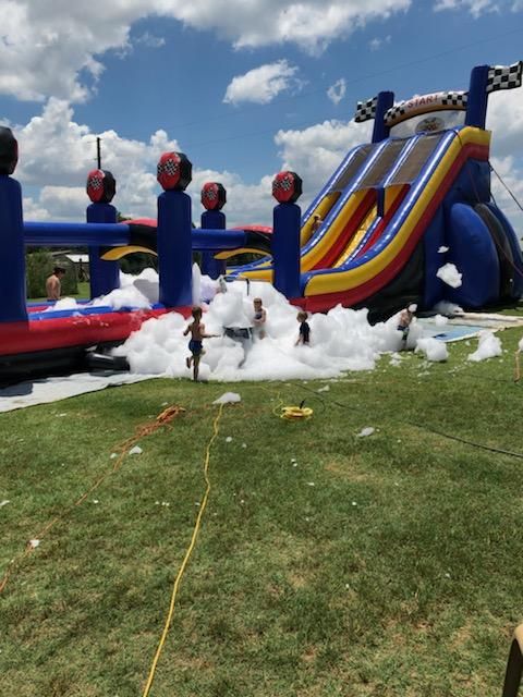 an inflatable water slide is being used as a playground for children to play