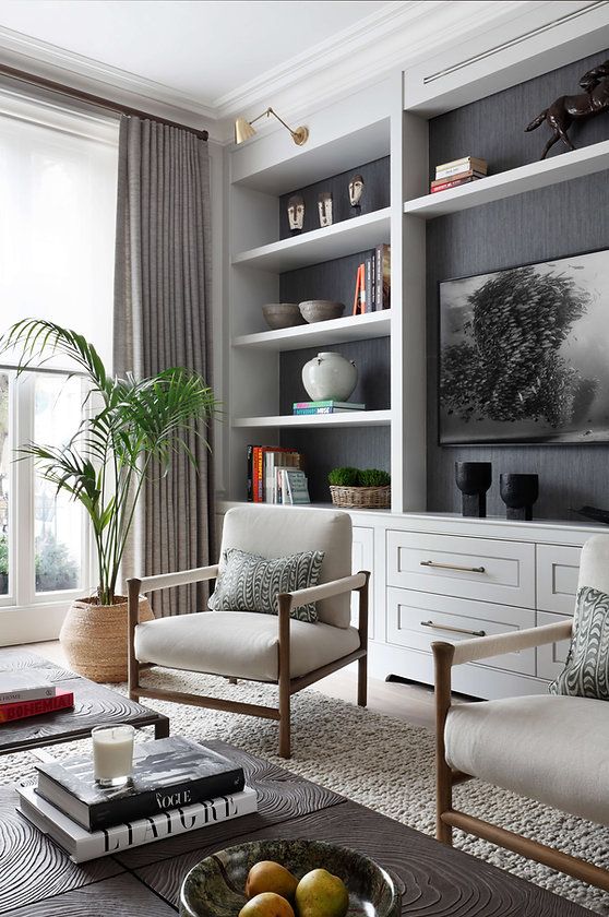 a living room with two chairs and a coffee table in front of a large window