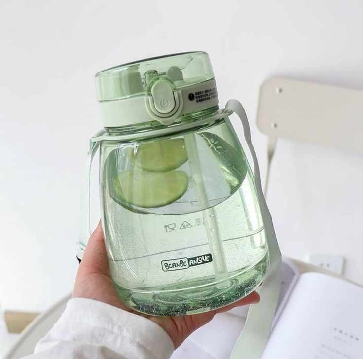 a person holding a jar with some fruit inside