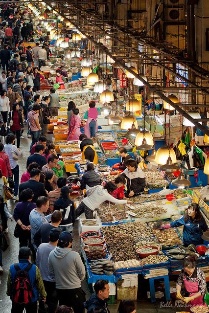 many people are shopping at an indoor market