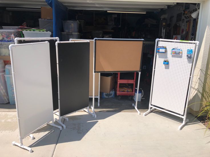 three screens are standing in front of a garage